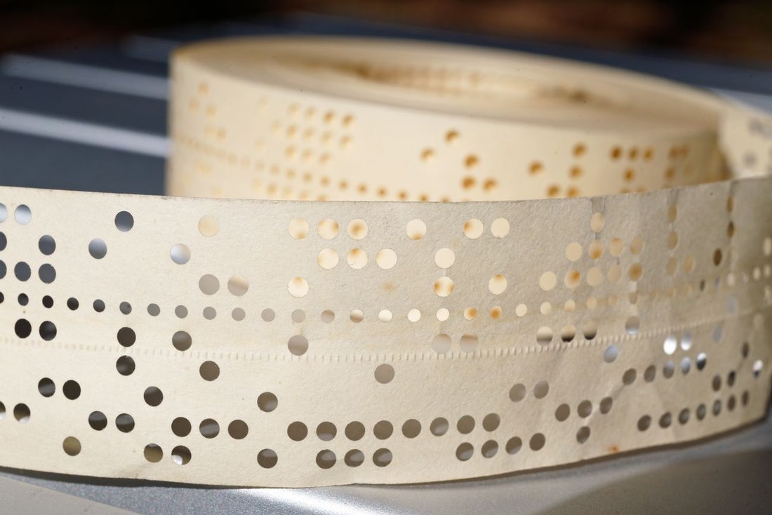 Figure 4 — A roll of punched paper tape — a message you can hold, store on a shelf, and feed back into a machine years later. (Jud McCranie, Wikimedia Commons, CC BY-SA 4.0.)